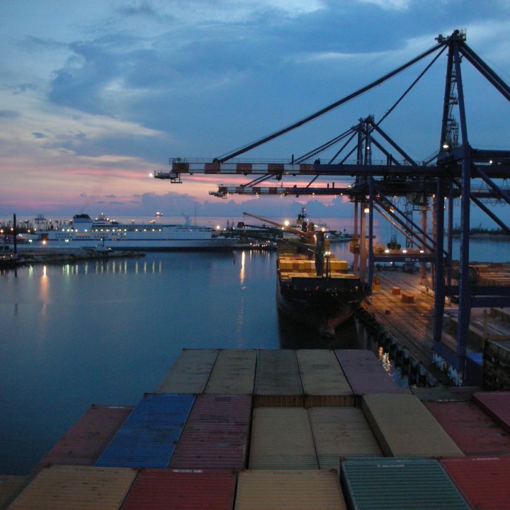Sunset view of container ship cranes in Freeport, Bahamas harbor
