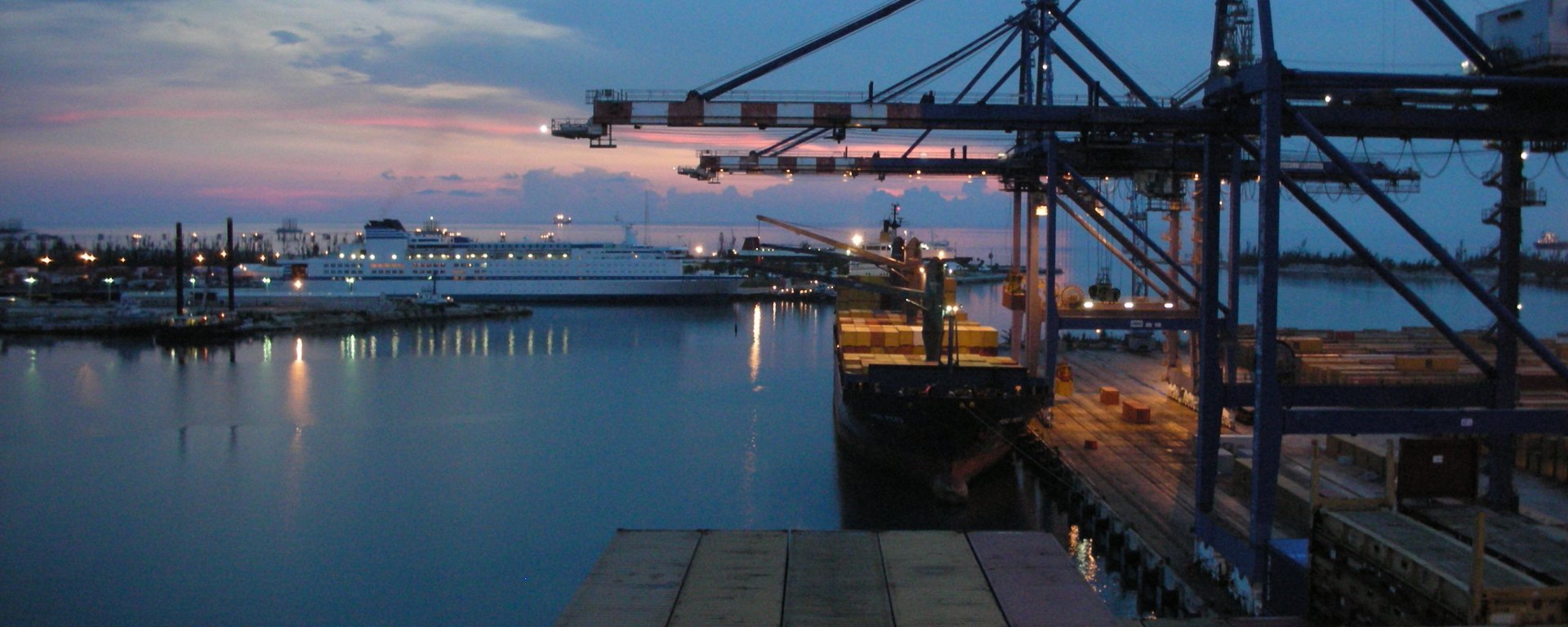 Sunset view of container ship cranes in Freeport, Bahamas harbor