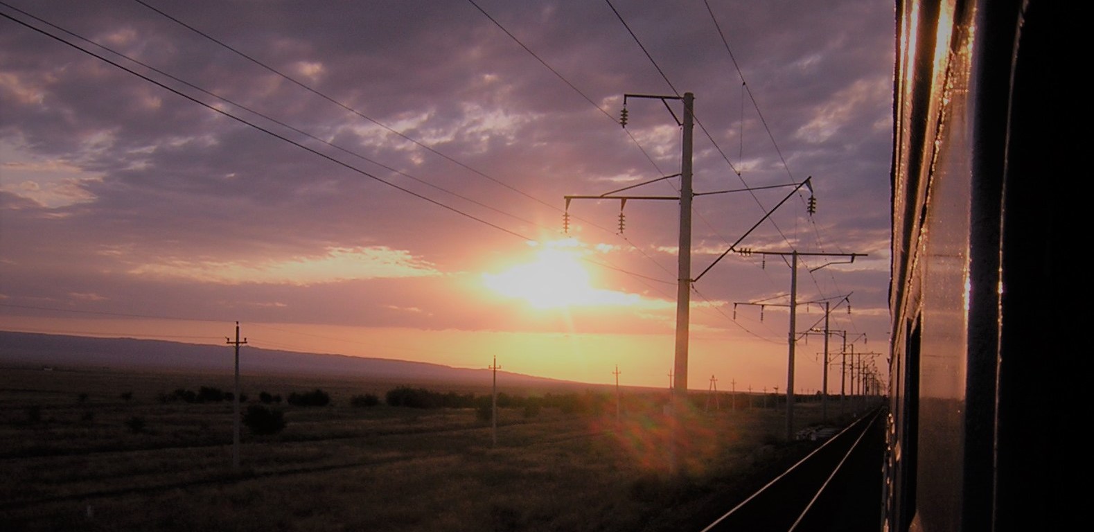 Sun setting over the Kazakhstan steppe from train window