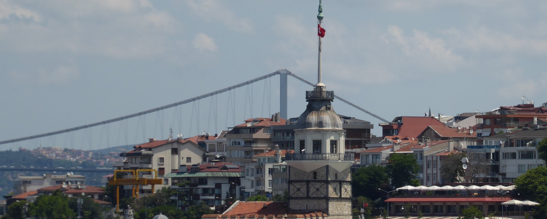 Small tower on island in the Bosphorus strait with big bridge in background