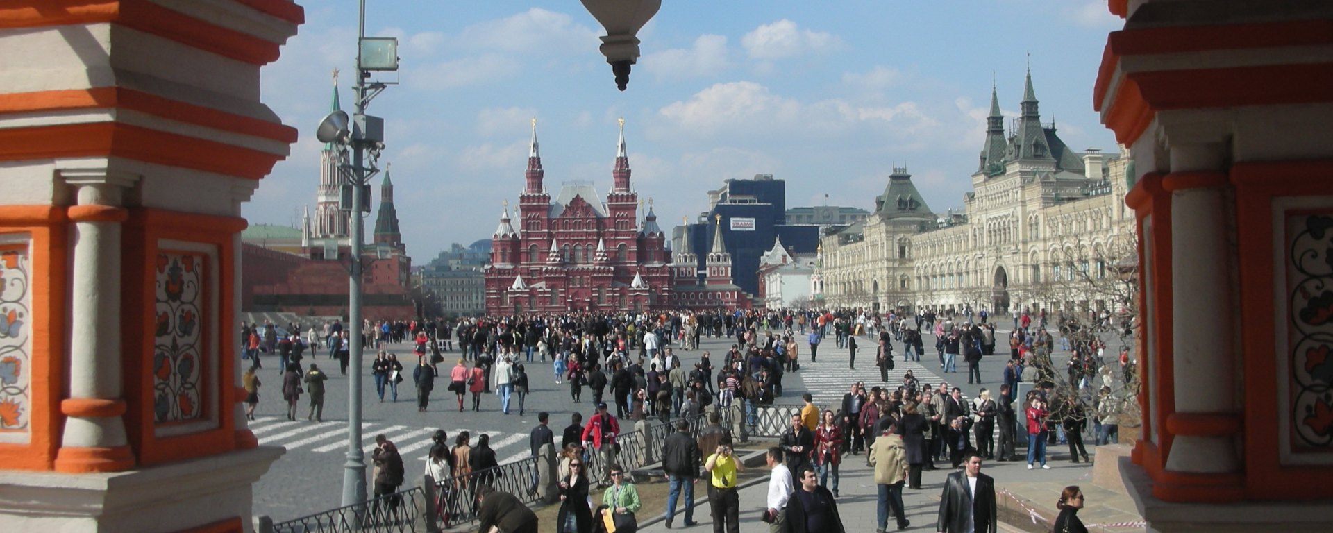 Moscow's Red Square seen from inside church arches with big red and white buildings in background