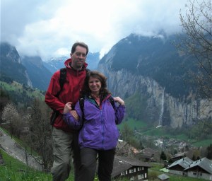 couple holding hands with deep valley and waterfalls behind