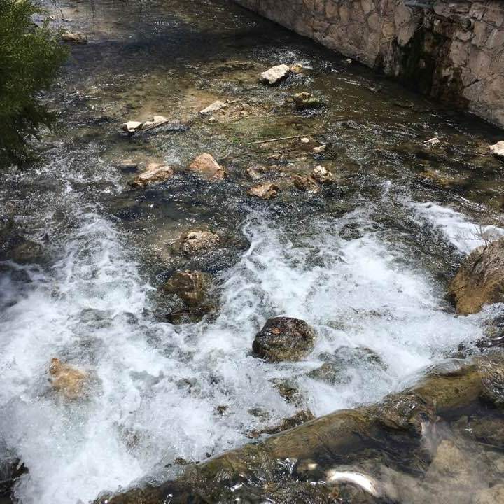 the natural warm waters spill over rocks at the fish spa center