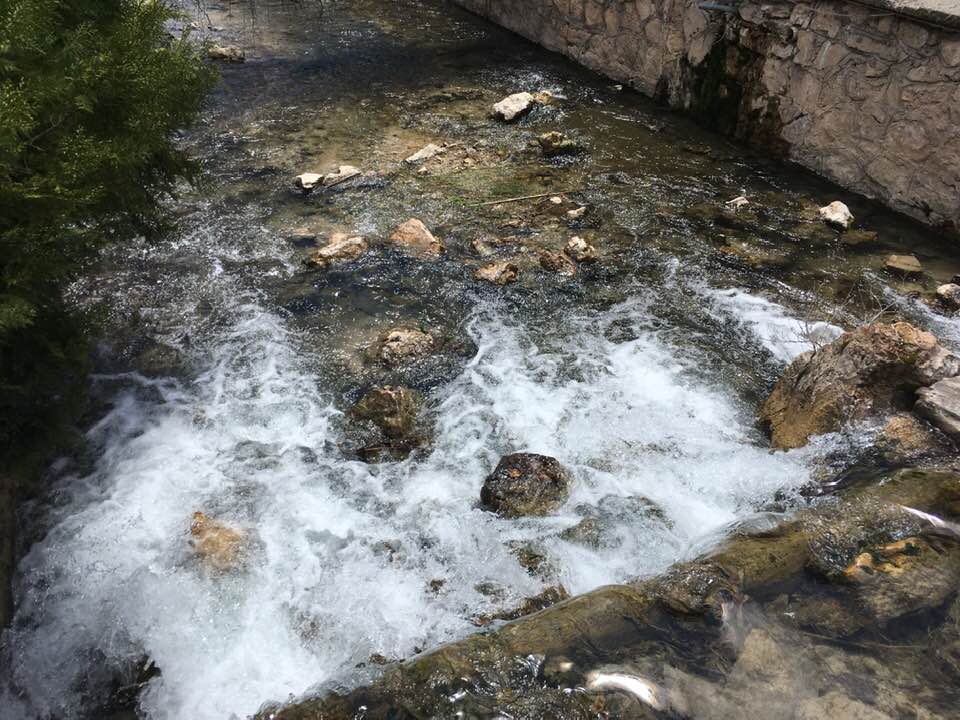the natural warm waters spill over rocks at the fish spa center