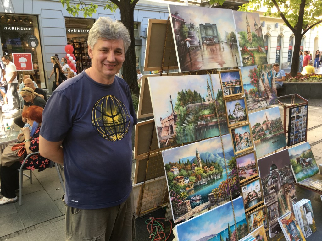 painter displaying artwork on Belgrade city street