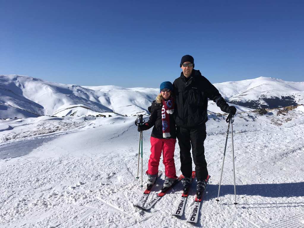 man and woman skiers atop mountain