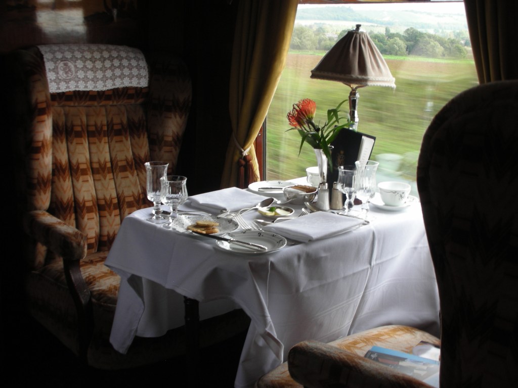 fancy train dining car table set with white china and crystal
