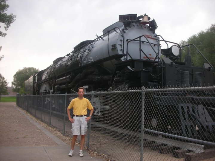 man in front of giant steam train